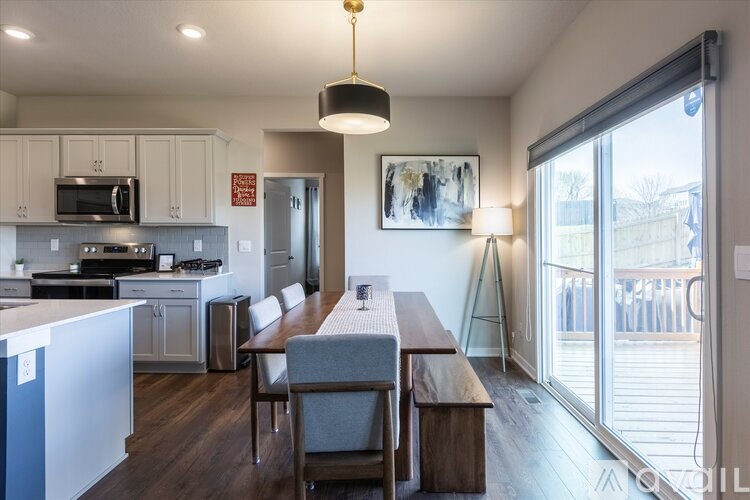 A modern kitchen with a dining table and chairs.