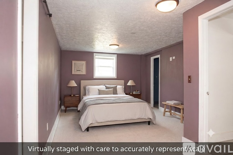 A bedroom with a bed, nightstands, and a window.