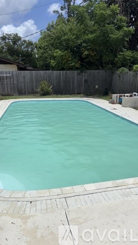 A small residential pool with a concrete border.