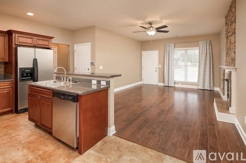 A kitchen with wooden cabinets and a stainless steel refrigerator.