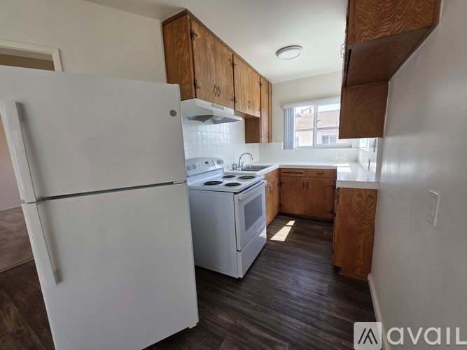 A kitchen with a white refrigerator and a white stove top oven.