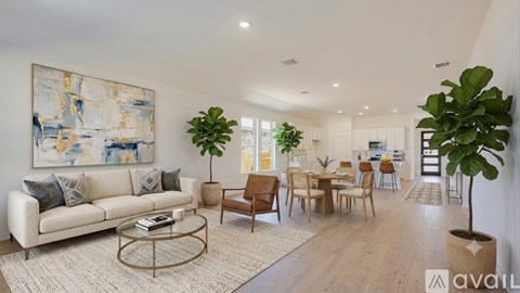 A living room with a white couch, a coffee table, and a large painting on the wall.