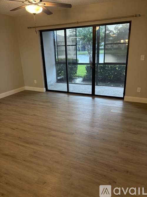A room with a sliding glass door leading to a backyard.
