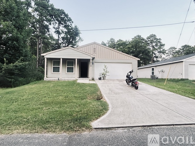 A motorcycle is parked on a driveway leading to a house.