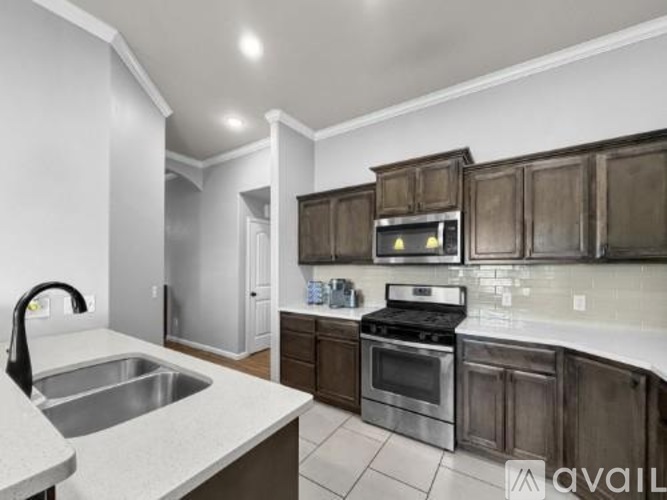 A kitchen with dark wood cabinets and stainless steel appliances.