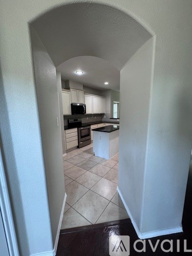 A kitchen with white cabinets and a black countertop.