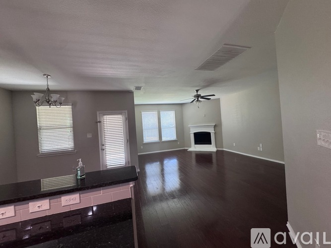 A spacious room with a fireplace and a ceiling fan.