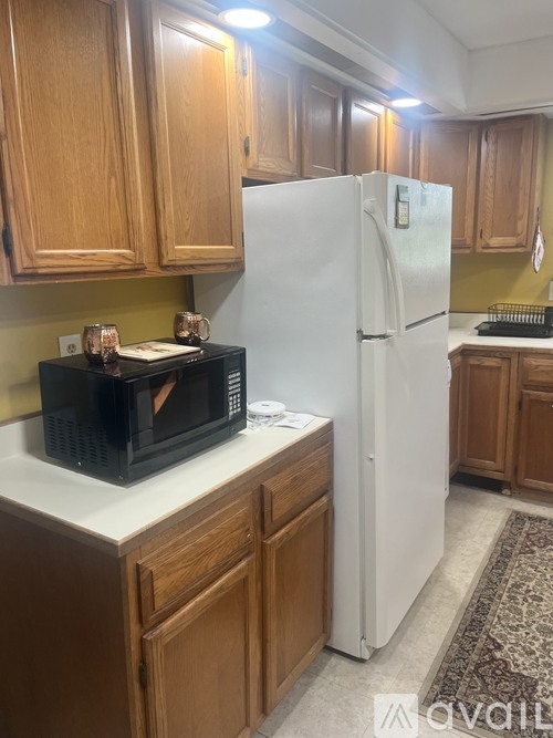 A kitchen with wooden cabinets and a white refrigerator.