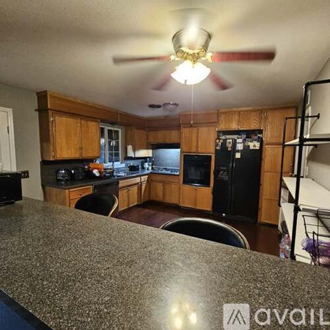 A kitchen with wooden cabinets and a granite countertop.