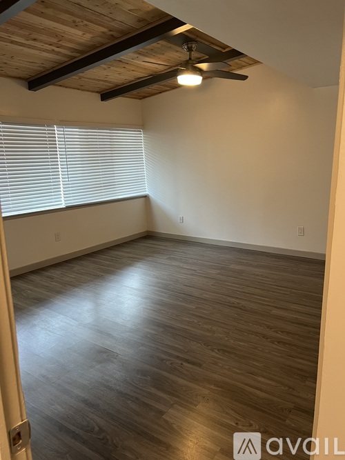 A room with wooden flooring and a ceiling fan.