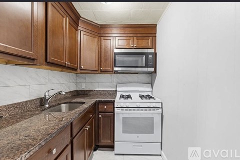 A kitchen with brown cabinets and a white stove top oven.