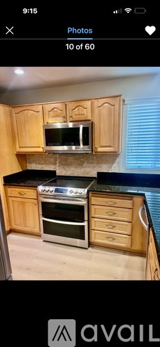 A kitchen with wooden cabinets and a black countertop.