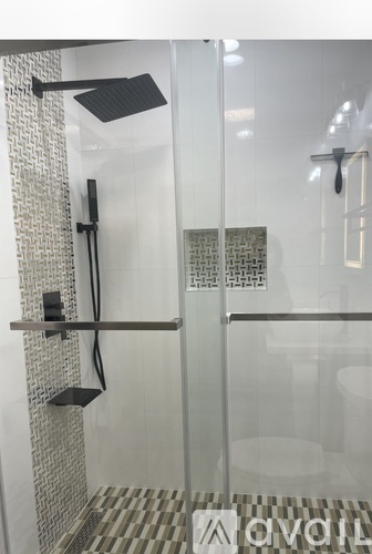 A modern bathroom with a glass shower stall and a glass door.