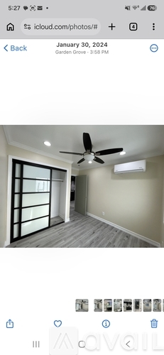 A room with a ceiling fan and a window with blinds.