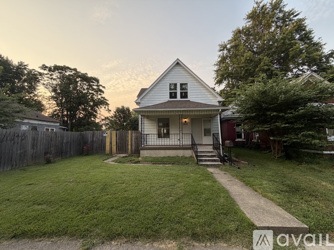 A house with a white front porch and a black metal railing.