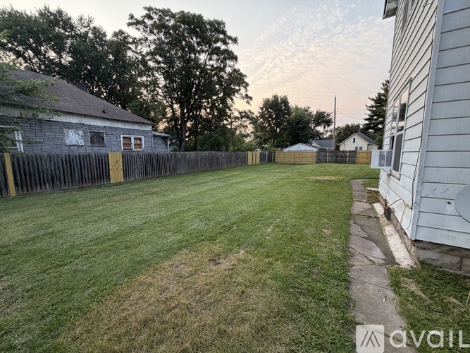 A backyard with a fence and a house.