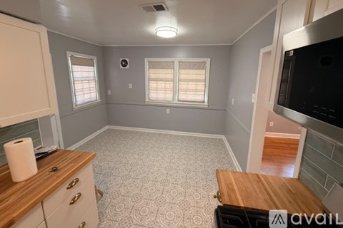 A kitchen with a wooden counter and a microwave.