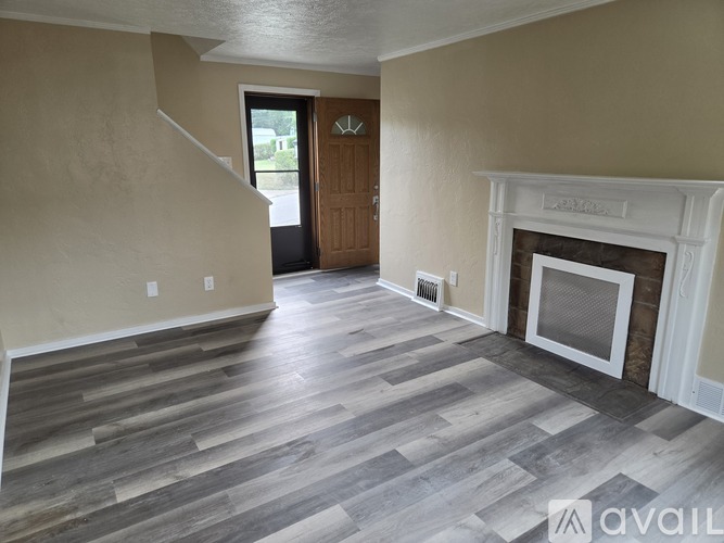 A living room with a fireplace and wood flooring.