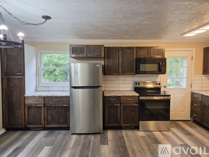 A kitchen with wooden cabinets and a stainless steel refrigerator.
