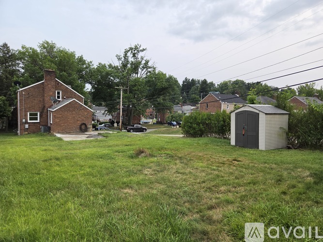 A grassy area with a house and a shed.