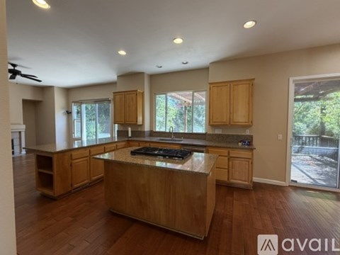 A kitchen with wooden cabinets and a marble countertop.