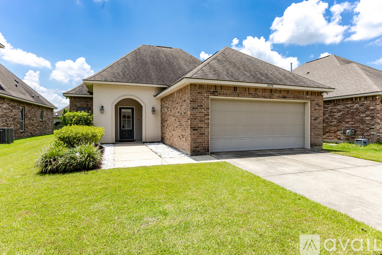 A house with a garage and a driveway in front.