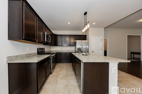 A kitchen with black cabinets and granite countertops.