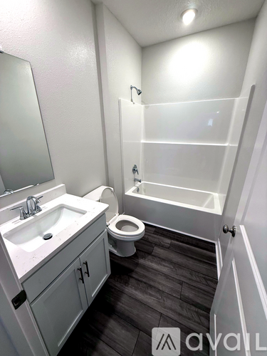 A bathroom with a toilet, sink, and bathtub.