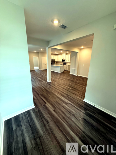 A room with wooden flooring and a white wall.