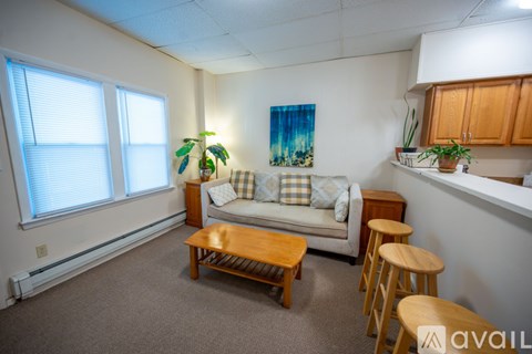 A living room with a couch, a coffee table, and a painting on the wall.