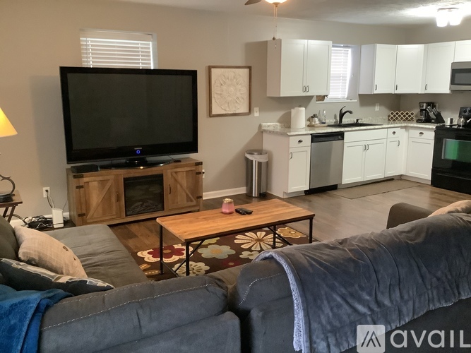 A living room with a grey couch and a wooden coffee table.
