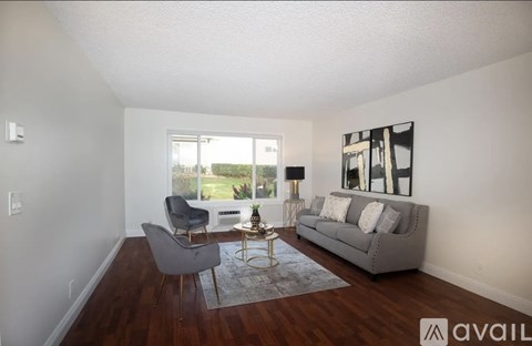 A living room with a grey couch, a grey chair and a coffee table.
