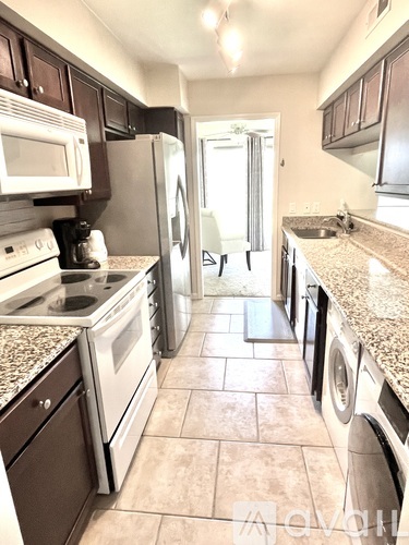 A kitchen with a white stove top oven and a white refrigerator.