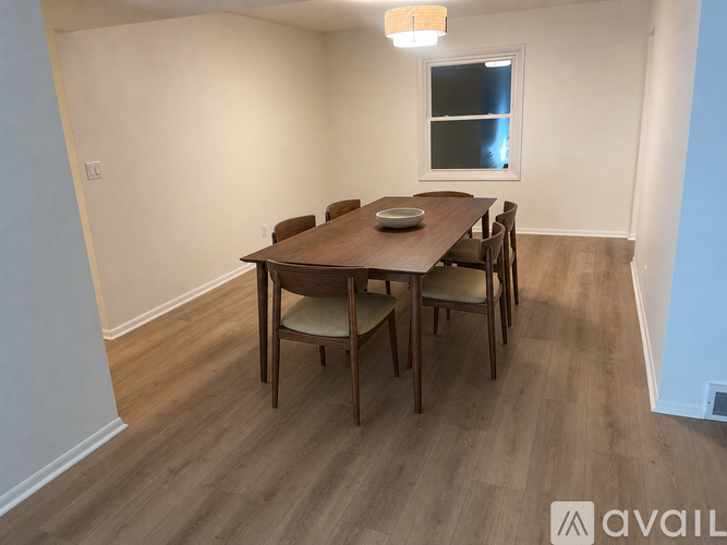 A dining room with a wooden table and chairs.