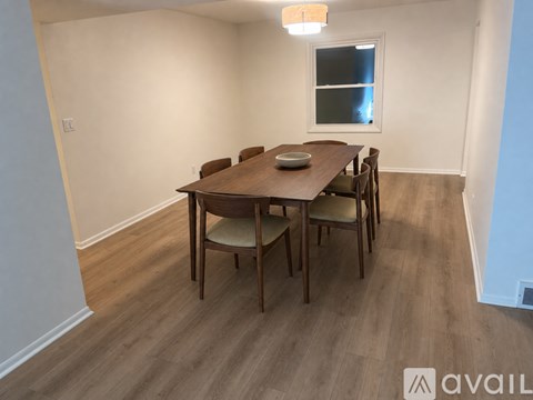 A dining room with a wooden table and chairs.