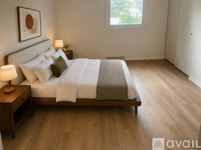 A bedroom with a large bed and a lamp on a nightstand.