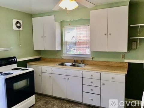 A kitchen with white cabinets and a black stove top oven.
