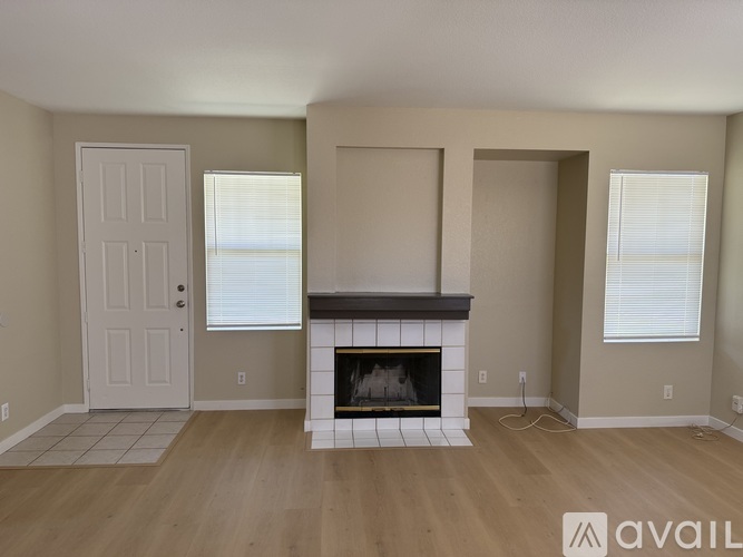 A living room with a fireplace and two doors.