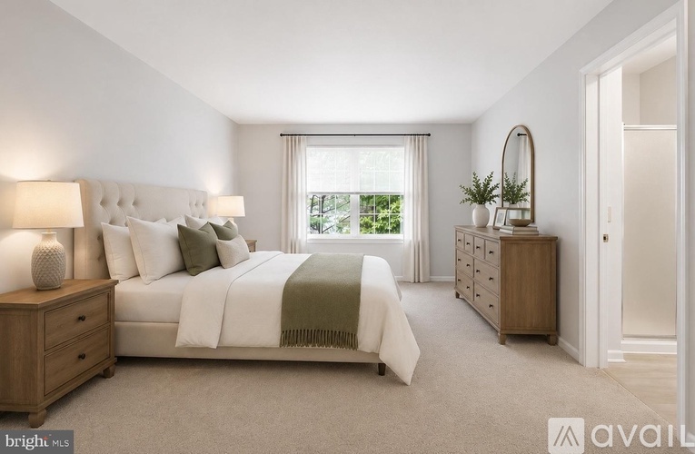 A bedroom with a large bed, a nightstand, and a dresser.