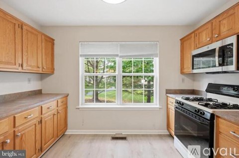 A kitchen with wooden cabinets and a window.
