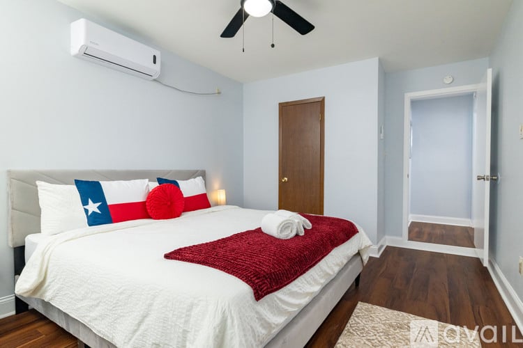 A bedroom with a bed, pillows, and a ceiling fan.