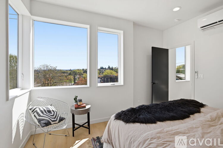 A bedroom with a large bed and a chair by the window.