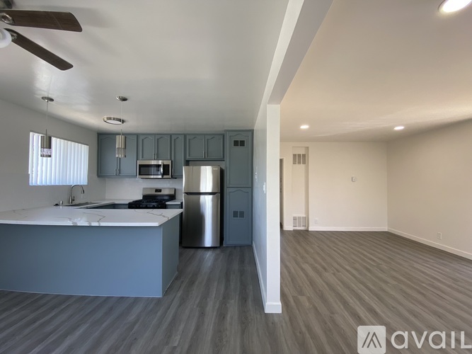 A spacious kitchen with a refrigerator, microwave, and oven.