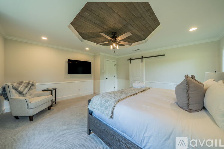 A bedroom with a large bed and a chair.
