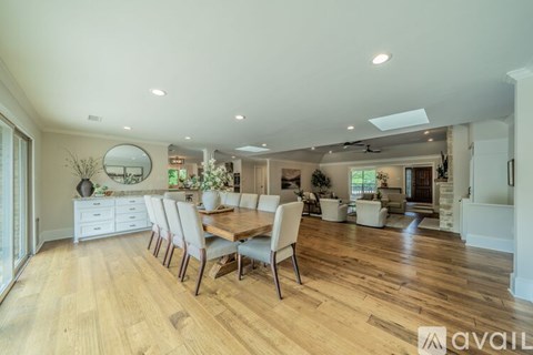 A dining room with a long table and chairs.