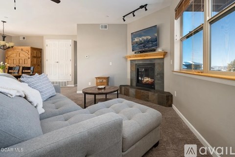 A living room with a grey couch and a fireplace.