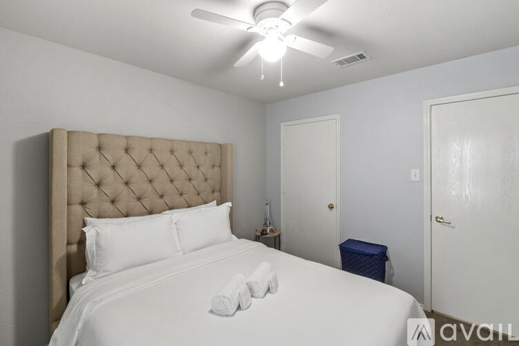 A bedroom with a large bed and a ceiling fan.