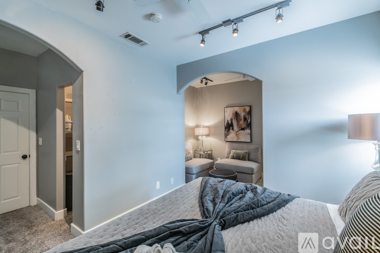A bedroom with a large bed and a picture on the wall.