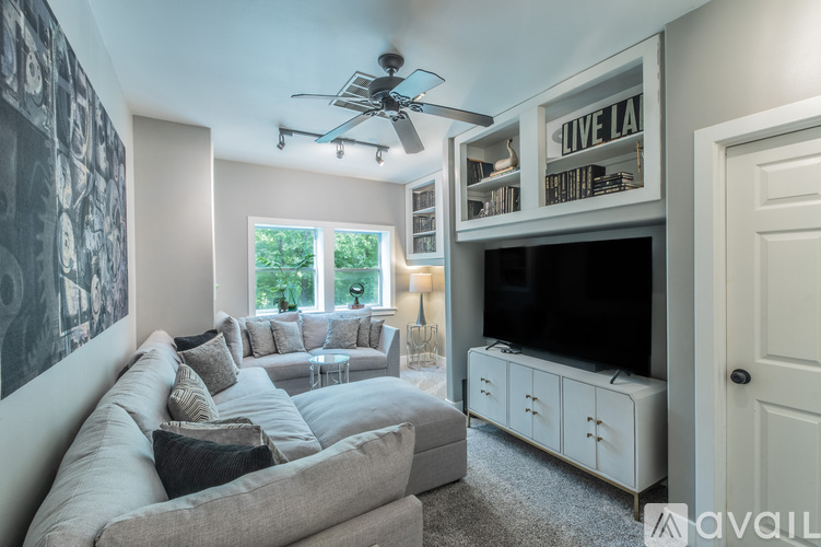 A living room with a grey sofa and a white cabinet.