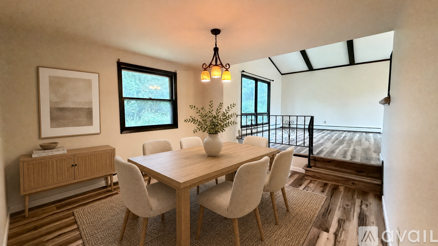 A dining room with a wooden table and chairs.